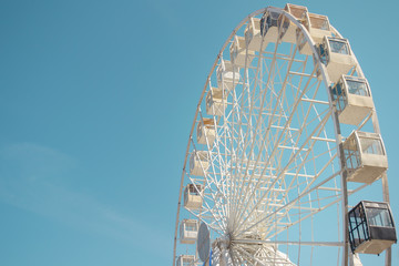 Big city ferris wheel on a background of clean blue sky
