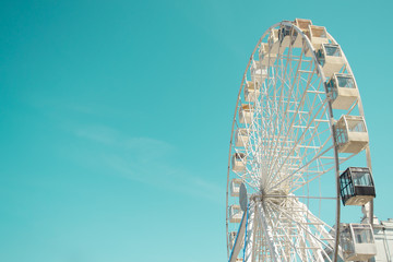 Big city ferris wheel on a background of clean blue sky