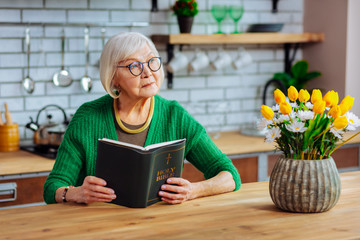 Attractive lady in years holding an open Holy Bible