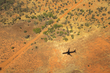 Central Australia land view from above, with the shadow of the airplane