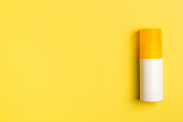 sunblock on yellow background. top view, copy space