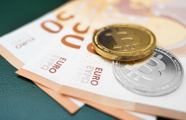 Bitcoin coins cryptocurrency lying on the euro banknotes.