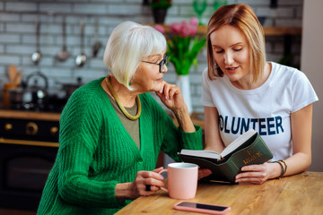 Attractive woman doing Bible reading with appealing aged female