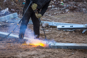 A worker cut steel beams using propane-oxygen torch..Oxy-fuel cutting.