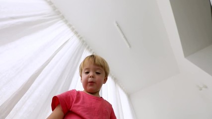 Child unboxing an electric toy car all-terrain vehicle out of the box on the background, the white interior of the apartment. Little boy opens a parcel box of emotions and being surprised. - Powered by Adobe