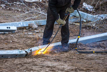 A worker cut steel beams using propane-oxygen torch..Oxy-fuel cutting.