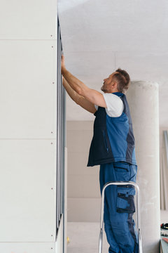 Worker Preparing Wall For Installing Drywall