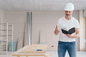 Builder or engineer looking at his notes