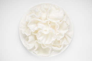 Crispy shrimp chips on a white background. Prawn cracker krupuk in a bowl top view.