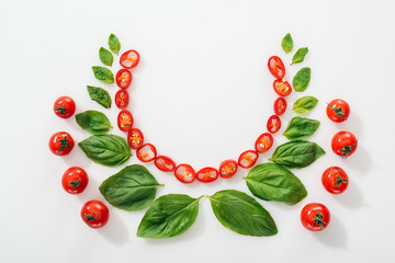 flat lay with cut chili peppers, basil leaves and ripe cherry tomatoes on white background with copy space