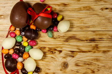 Easter composition with chocolate eggs on wooden background