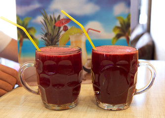 2 two glasses of pomegranate juice isolated in blurry background in the street bar. Vitamins and minerals. Healthy drink concept