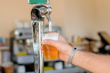 Man pouring fresh beer in self service bar - with all inclusive badge
