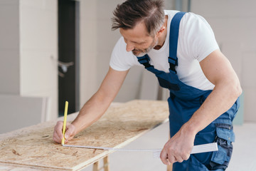 Builder measuring OSB sheet