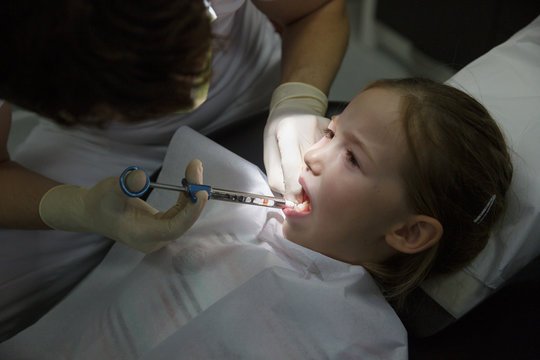 Scared Little Girl At Dentist Office, Getting Local Anesthesia Injection Into Gums, Dentist Numbing Gums For Dental Work.