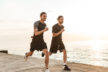 Two twin brothers doing exercises at the beach