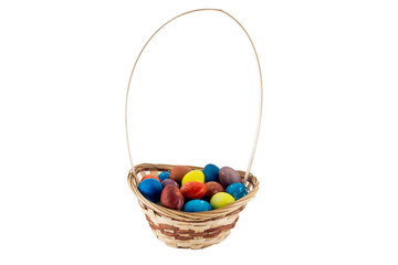 Colorfull Easter eggs in wicker basket isolated on white background