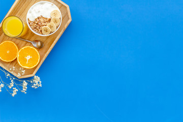 Bright breakfast with granola and orange juice on blue background top view mockup