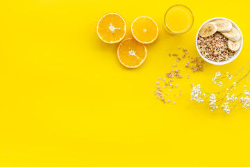 food for healthy breakfast with granola and fresh orange juice on bright yellow background top view mock up