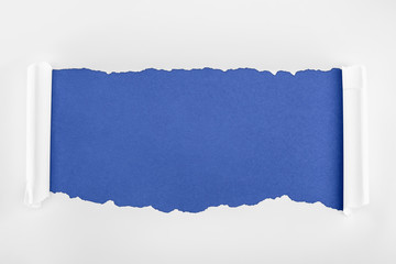 ragged textured white paper with curl edges on blue background