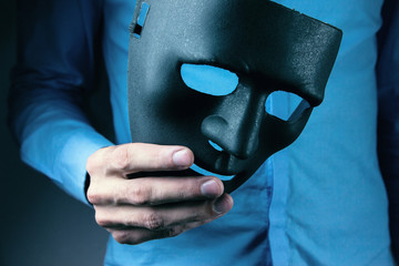 man holds mask in his hand