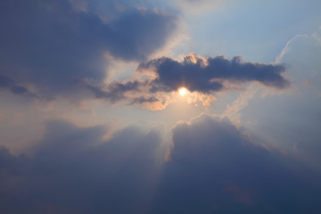 Naklejka na ściany i meble Beautiful crepuscular ray of sunlight shines through the cloud 