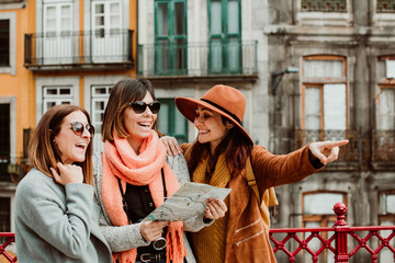 .Three beautiful and funny women traveling together in Porto, Portugal. Standing together carefree...