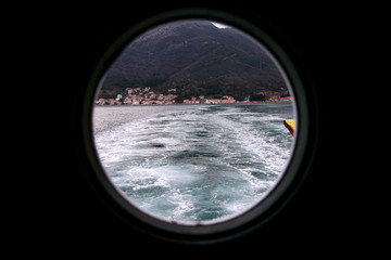 Hinged round window, storm cover on ship looking outside into Mediterranean sea. Porthole view...