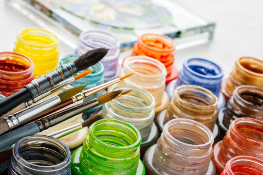 Stained glass paints and paint brushes, artisan painting  on a glass surface.