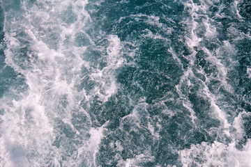 Turbulence made by foam of sea water from a high-speed yacht on surface of sea. Blue sea waves with...