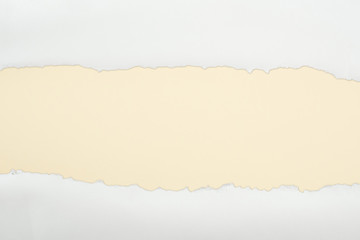 ragged white textured paper with copy space on beige background