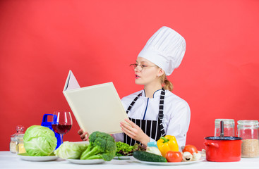 Book that will make you really hungry. Lady cook looking for recipe in cookery book. Pretty woman reading cook book in kitchen. Kitchen maid learning new dishes from recipe book