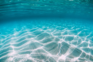 Tropical blue ocean with white sand underwater in Hawaii