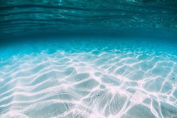 Tropical blue ocean with white sand underwater in Hawaii