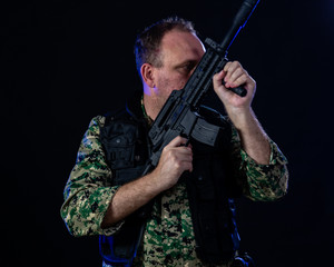 Fototapeta na wymiar Soldier holding assault rifle