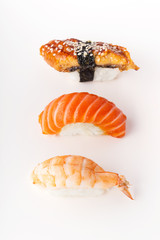 Creative layout with various sushi on white background. Shrimp, eel, salmon.