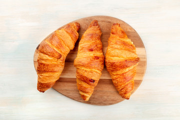 Naklejka na ściany i meble A high key photo of croissants, shot from above on a white wooden background with a place for text