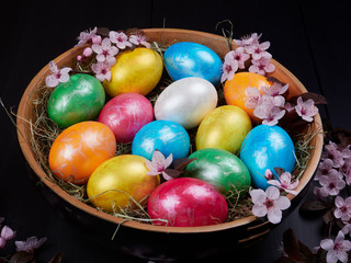 Colorful Easter eggs in a wooden bowl