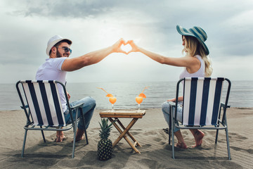 Couple on a deck chair relaxing on the beach. Happy couple enjoy on the beach during summer...