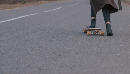 girl model skateboarding on a rural road, close-up,