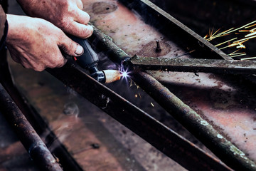 Cutting steel with plasma. Male welder cuts metal plasma.