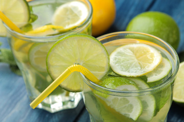 Mojito cocktail in a glass glass with lime, mint and lemon on a blue wooden table. make a mojito.