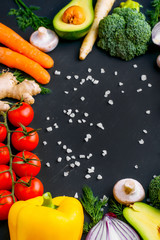 Vegan healthy food. Vegetables and fruits. On a black background. Top view. Copy space.