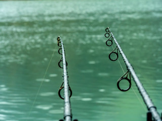Two carbon fishing rods in the rain waiting for fish to bite