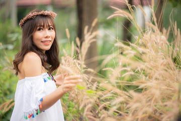 A portrait of a asian beautiful hippie girl in white dress on a field. Bohemian Style.
