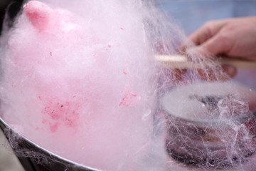 Cotton candy being made out of pink dyed sugar for joyful children. Concept of unhealthy eating,...
