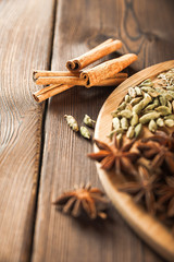 Seasoning on a textured wooden background close-up and copy space. Cinnamon, star anise, fennel, cloves, seasoning tea masala as a texture