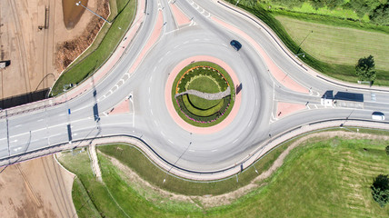 Top down aerial drone view of newly made asphalt road, traffic roundabout in city. Concept of...