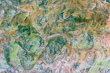 Green, orange, blue and yellow sedimentary rocks - colourful rock layers formed through cementation and deposition - abstract graphic design backgrounds, patterns, textures