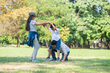 Fototapeta premium Happy children and parents playing in the park. Concept family relaxation.